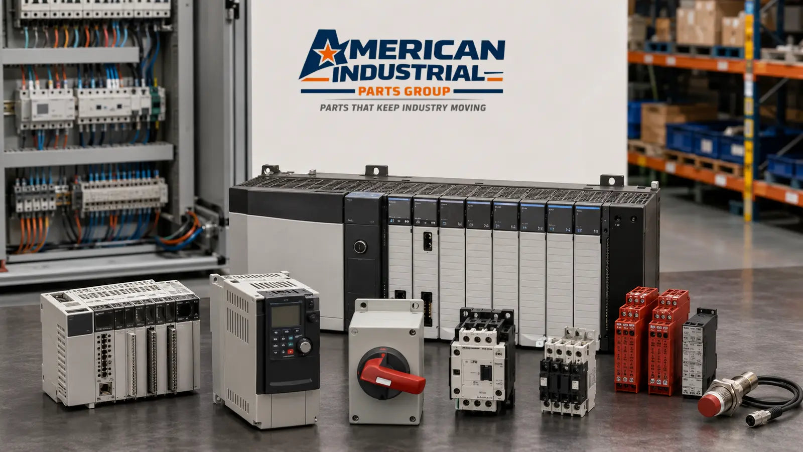 A collection of industrial electrical components, including control modules, a variable frequency drive, a red rotary switch, and contactors, arranged in front of a white sign that reads 'AMERICAN INDUSTRIAL PARTS GROUP' in a warehouse setting.
